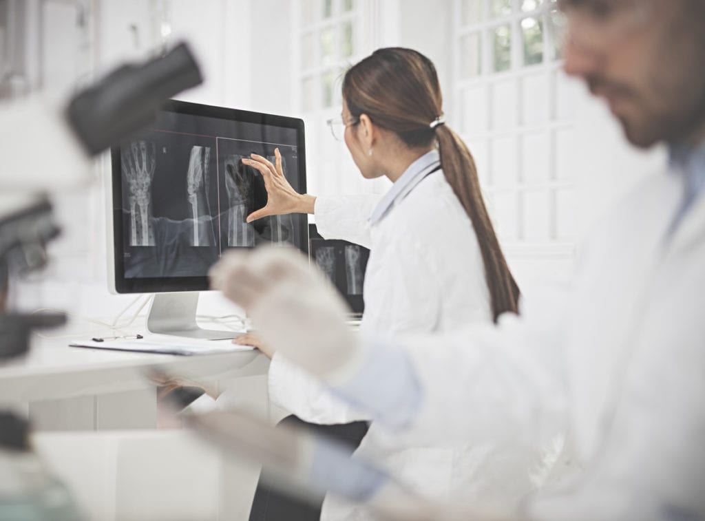 female radiologist examining X-ray image on computer