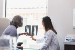 Female patient and her doctor looking at foot xrays