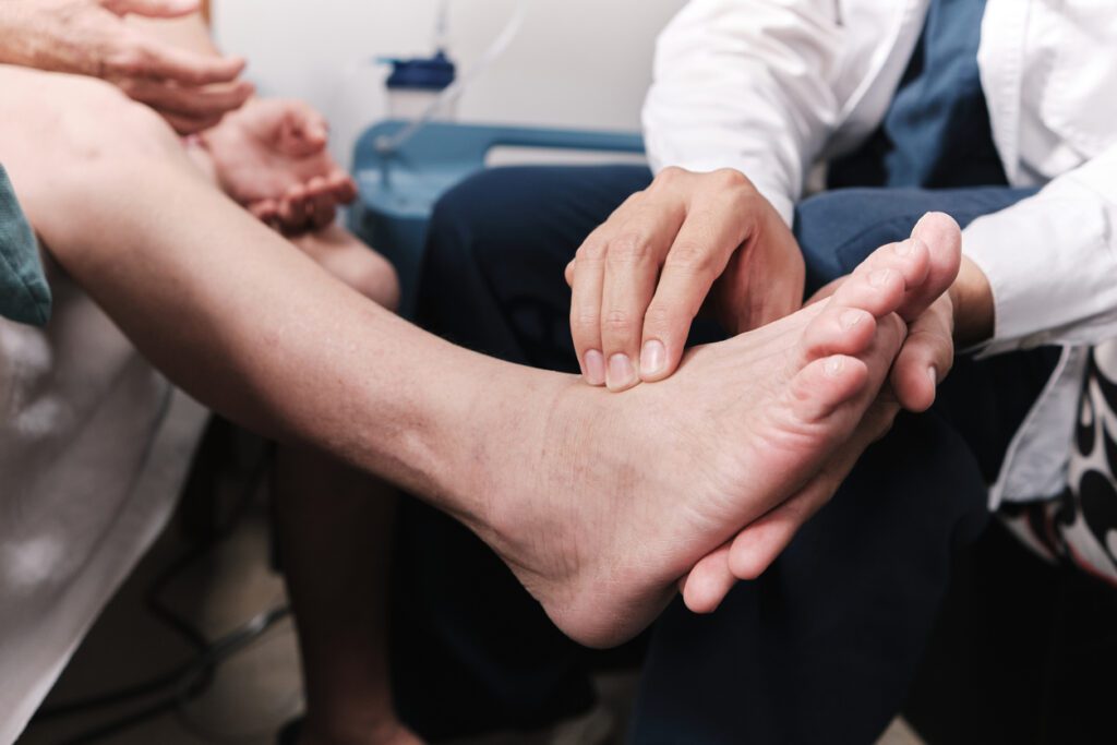 Foot doctor taking patient's pulse in the foot