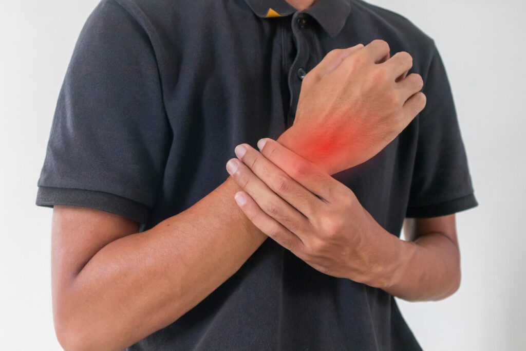 A man is holding his painful wrist from carpal tunnel syndrome.