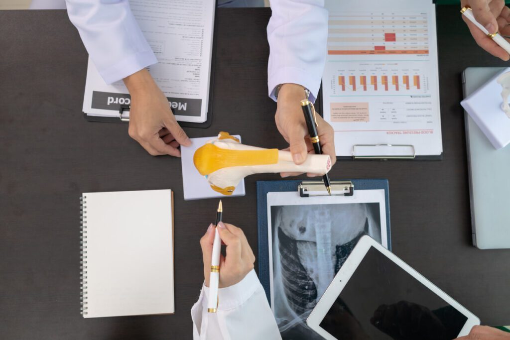 The doctor joins a meeting with the surgeon's team to discuss a plan for an orthopedic surgery.