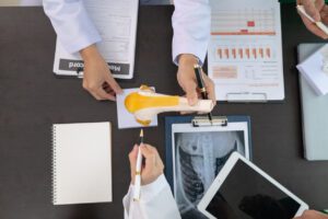 The doctor joins a meeting with the surgeon's team to discuss a plan for an orthopedic surgery.